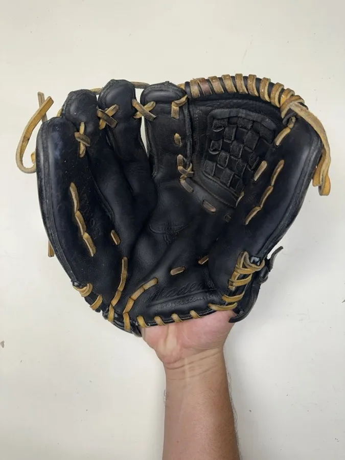 Akadema baseball glove before restoration — worn leather and frayed laces
