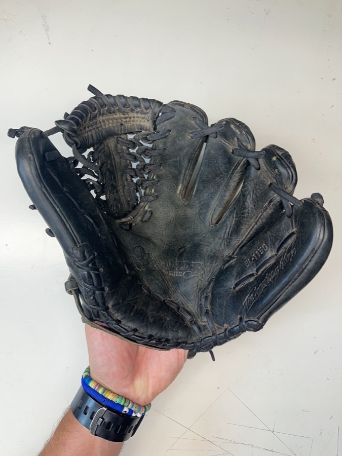 Nokona baseball glove before restoration — worn leather and frayed laces