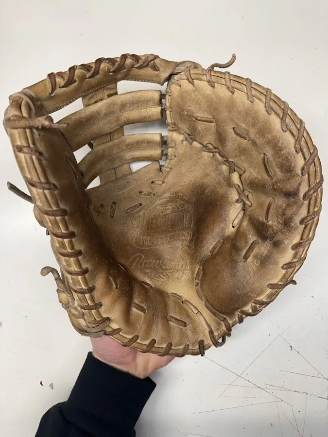 Rawlings baseball glove before restoration — worn leather and frayed laces