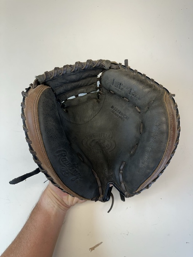 Rawlings baseball glove before restoration — worn leather and frayed laces