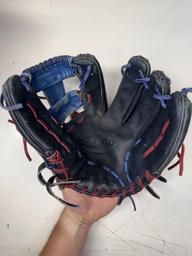 Wilson baseball glove before restoration — worn leather and frayed laces
