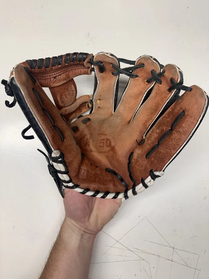 Wilson baseball glove before restoration — worn leather and frayed laces