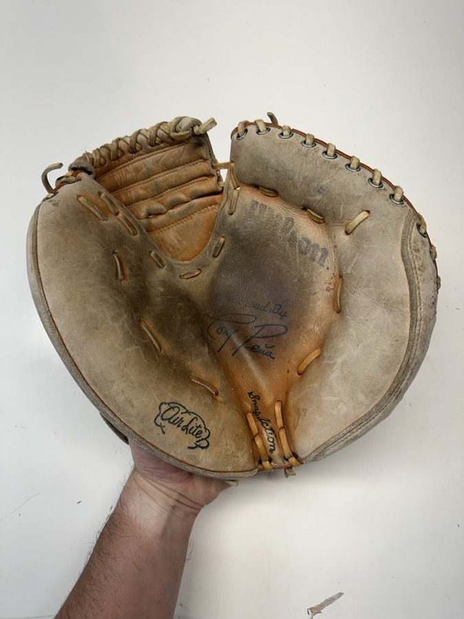 Wilson baseball glove before restoration — worn leather and frayed laces