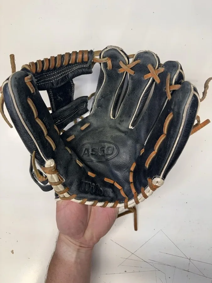 Wilson baseball glove before restoration — worn leather and frayed laces
