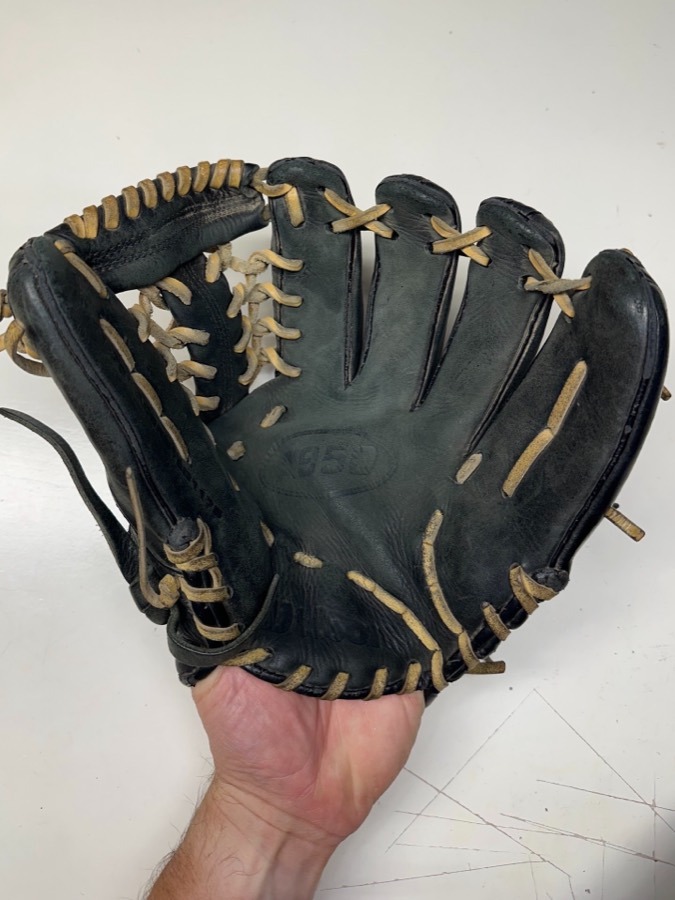 Wilson baseball glove before restoration — worn leather and frayed laces