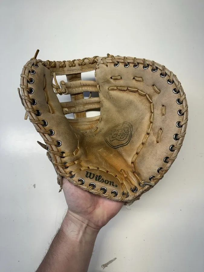 Wilson baseball glove before restoration — worn leather and frayed laces