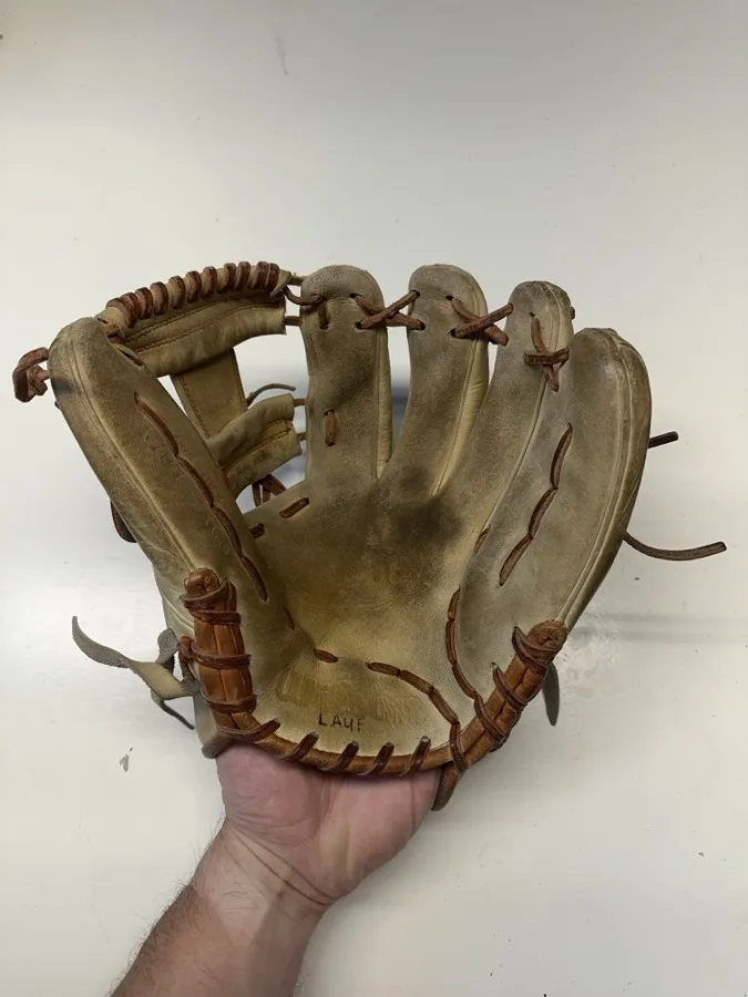 Wilson baseball glove before restoration — worn leather and frayed laces