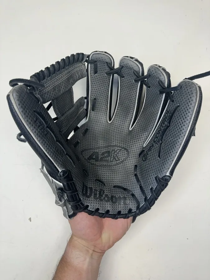 Wilson A2K baseball glove before restoration — worn leather and frayed laces